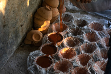 Artisanal Food Craft: Rows of Unrefined Sugar Setting Near Stacked Clay Pots