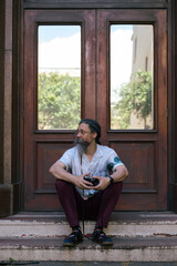 Man seen sitting on staits with vintage camera in hand