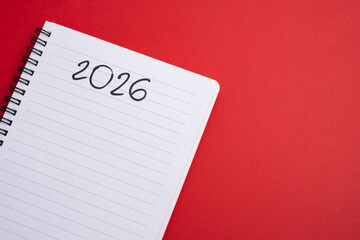Happy New Year 2026 and a notepad on a colored background. Layout for writing annual business...