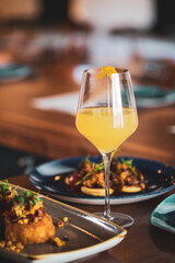 A glass of white wine on a table at a restaurant served with food at an upscale restaurant

