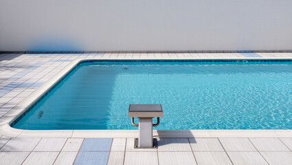 Obraz premium Serenity found by the sparkling blue waters of a tranquil poolside