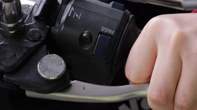 Close-up of a hand gripping and pressing the motorcycle throttle handle, showcasing control, power and motorbike riding concept. Motorcycle rider squeezing the engine throttle handle