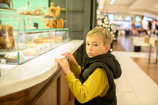 Boy walking through a modern shopping mall, exploring stores and enjoying a casual indoor outing, capturing a candid moment of childhood in an urban environment.