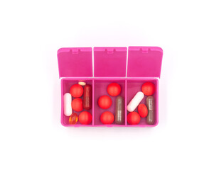 A pill organizer with compartments on a white background. A pillbox for daily medications for maintaining good health.