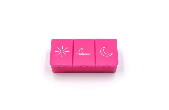 A pill organizer with compartments on a white background. A pillbox for daily medications for maintaining good health.