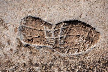 camino de hormigón donde aquedado las huellas de una zapatilla 