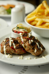 Tender mincemeat grilled with spices served with french fries and chilli peppers	