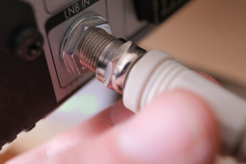 Hand removing or attaching antenna jack to LNB in.	
