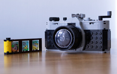 Naklejka premium lego vintage film camera with a film roll isolated on the table