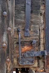 An old wooden door on a salt car. Close-up of the wood grain. Rusty hardware and nails.