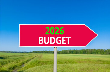 2026 Budget symbol. Concept words 2026 Budget on beautiful red road sign. Beautiful green grass field forest and blue sky background. Business and 2026 budget concept. Copy space.