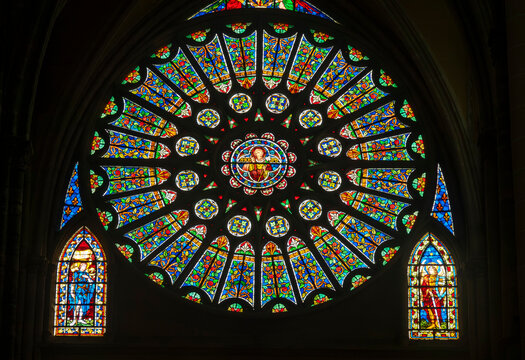 Stained glass (19th century) of a Gothic rose window with Christ at center.