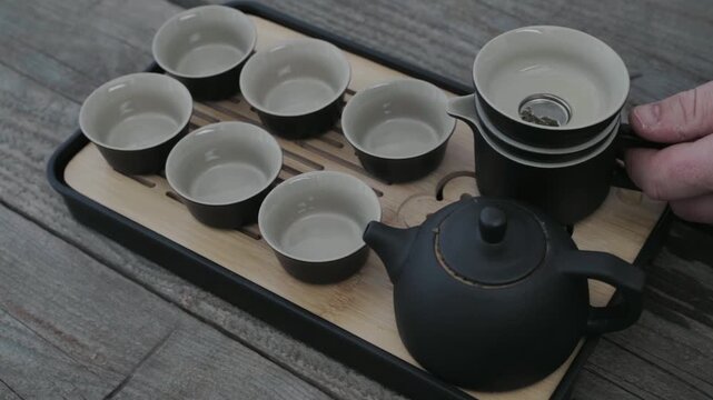 Man drinking green tea from Chinese tea set