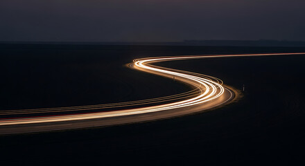 Long exposure light trails from cars on a winding road at night