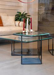 Modern decorative glass table with candles inside living room interior