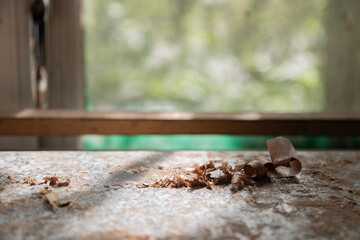 A close-up image of wood shavings scattered on a sunny surface, emphasizing the meticulous craftsmanship associated with woodworking and the beauty of natural materials.