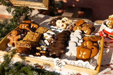 Assortment of gingerbread men, chocolate covered sweets, and christmas cookies displayed at a festive market stall during winter