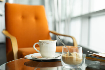 Coffee cup and sugar bowl on a coffee table, offering a moment of relaxation in a modern cafe setting