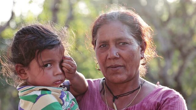 A close up shot of a village mountain grandmother holding her grandchild during sunset in Uttarakhand, capturing warmth, love, and the peaceful beauty of rural Himalayan life.