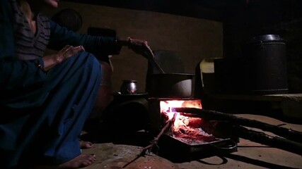A close-up shot of an Indian village woman boiling fresh cow’s milk on a traditional government-provided chulha stove, capturing rural lifestyle, daily chores, and authentic Uttarakhand household life