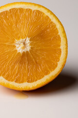Macro detail of a juicy half blond Sicilian orange, freshly cut, showing vibrant pulp texture and natural citrus freshness on a clean white background.