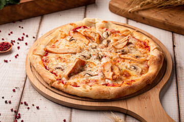 Classic chicken mushroom pizza on rustic wooden board with melted cheese and herbs