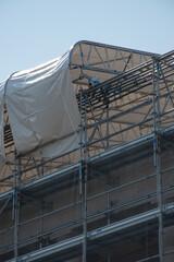 Scaffolding on the roof of a construction site to protect workers from the sun's rays and heat, Rome, Italy.