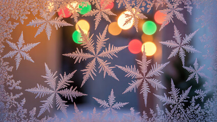 macro frost snowflake patterns on window with soft christmas lights