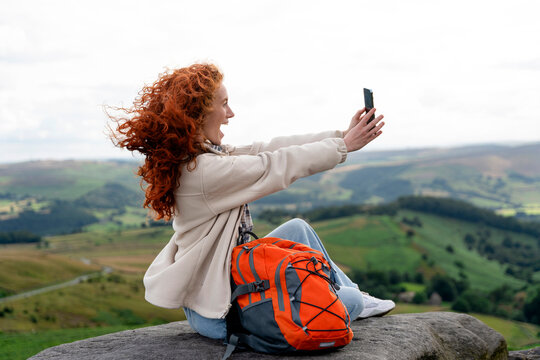 Enjoying a scenic moment while taking a selfie on a mountain - Powered by Adobe