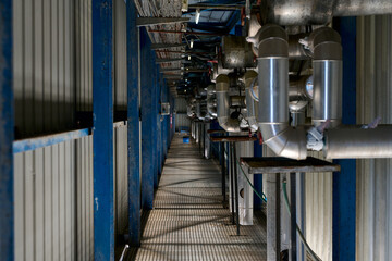 Industrial facility showing pipes, walkway, and blue structural support