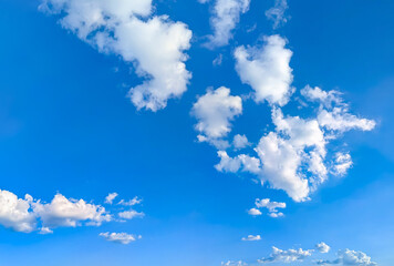 A feathery fanning of cumulus clouds in a serene, empty blue sky atmosphere. Panorama of cirrus and cumulus clouds viewed from below. Dramatic meteorological celestial spectacle. Blue skies in turmoil