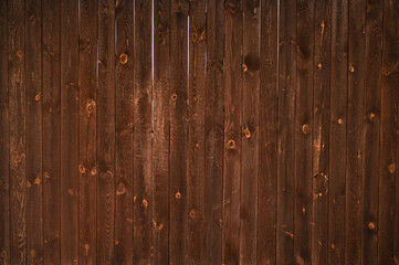 Rustic brown fence made of wooden planks with natural textured surface. abstraction background. Close-up of timber wall used as natural backdrop with rustic countryside style.