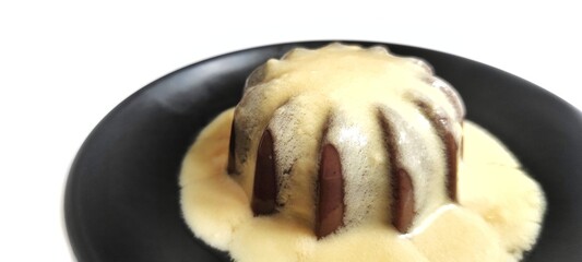 Chocolate Pudding with Creamy Vanilla Sauce  Custard on Black Plate Isolated on White Background. Food Stylish Photography