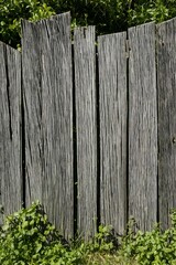 A weathered wooden fence with a fire hydrant