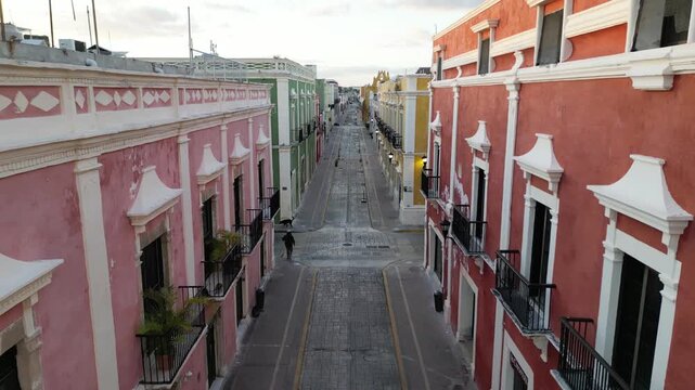 flying above scenic colorful colonial street in campeche yucatan peninsula (spanish architecture streetscape scene) gulf mexico sunrise glow cornice building beautiful downtown city center aerial view