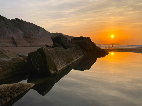 zumaia puesta de sol en la playa de itzurun con rocas al atardecer silueta y reflejo de mujer en el agua pa&iacute;s vasco IMG_2288-as25