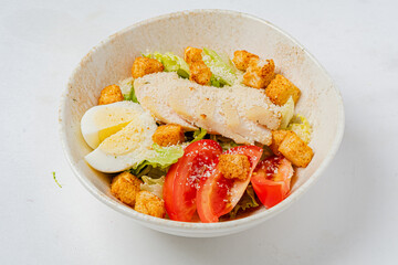 Vibrant salad with grilled chicken, tomatoes, croutons, and boiled eggs over lettuce