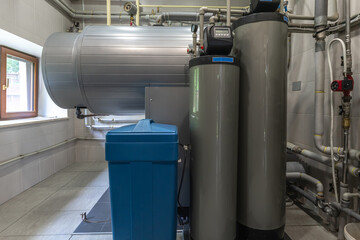 Utility room features a boiler, water tank, and various plumbing connections. Natural light streams through the window, illuminating the surroundings