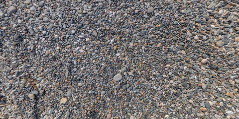 panorama view from above on surface of small pebbles and stones on sea coast