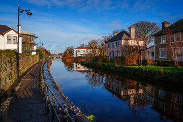 Vibrant, tranquil cityscape of Galway along the Eglington Canal with a view of traditional landmark...