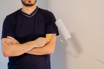 Portrait of a skilled painter or handyman posing with his main equipment, the paint roller. This image represents professional service and competence in the decorating trade.