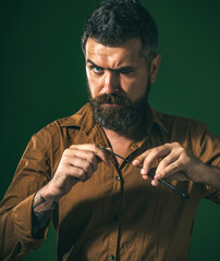 Man with beard in barbershop. Barber shows sharp blade of vintage straight razor. Barber shop. Brutal bearded man with straight razor in barbershop. Straight razor, barbershop. Handsome hairdresser.