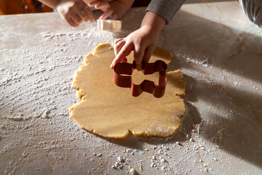 Kids&rsquo; Hands Cutting Festive Cookie Shapes in Flour-Dusted Dough