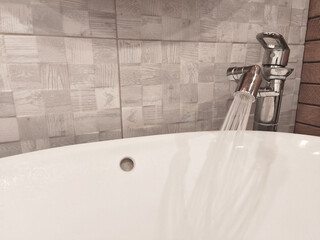 Metal Faucet with water-saving rotating Spray Nozzle. Aerator. Water flows Eco-friendly and environmentally friendly. Modern bathroom Tap near sink. Adapter to reduce water loss. Horizontal photo.