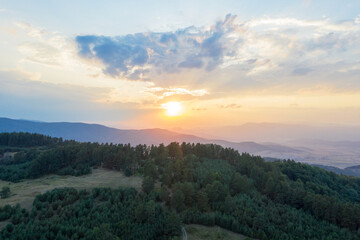 Beautiful landscape, the rising sun illuminated the slopes of the Rhodope Mountains covered in coniferous forest. Sunrise in the mountains. Travel and Vacation Concept in Bulgaria
