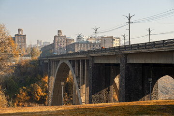 A bridge spans a river with a city in the background