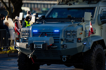 Armored military vehicle with Latvian flags, blue emergency lights and heavy front winch system...