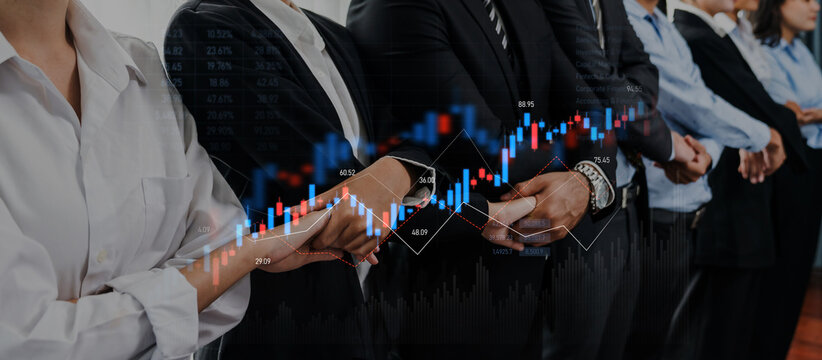 A group of professionals dressed in business attire stands together, showing hands and collaboration with a financial graph overlay, symbolizing success in modern economy. Trope