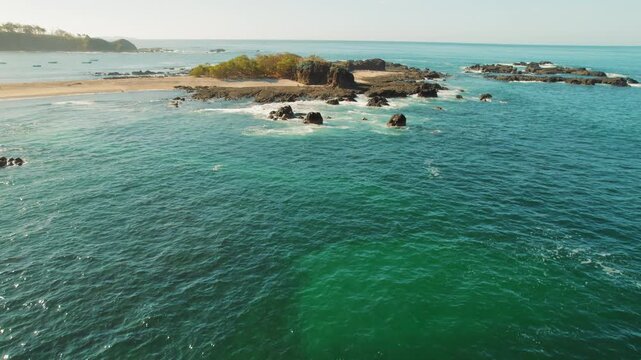 Small rocky peninsula surrounded by turquoise ocean and San Juanillo beach