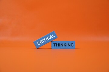 orange background highlights blue blocks with the words Critical and Thinking. Perfect for education, business, creativity, and brainstorming themes.